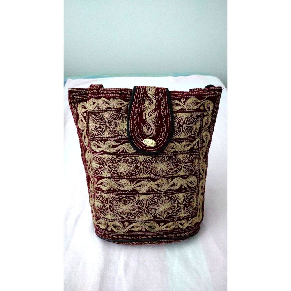 Maroon hobo bag features intricate gold embroidery and a "CLUB" branded clasp
